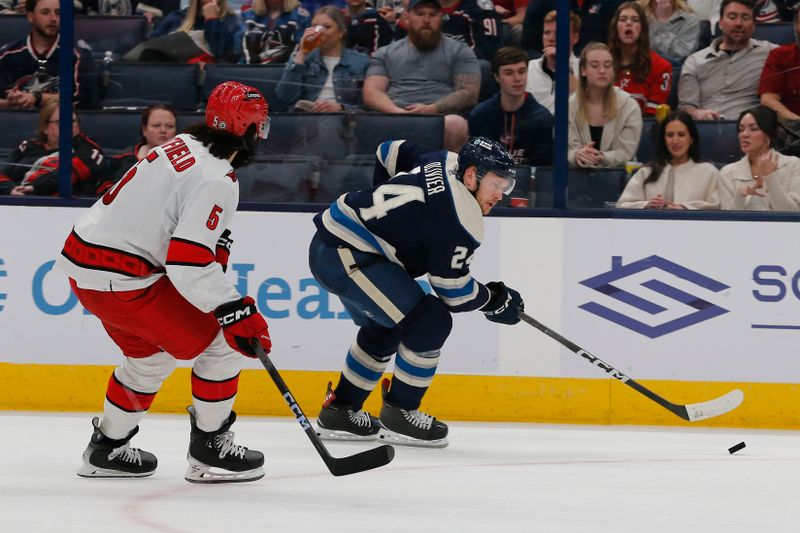 Apr 16, 2024; Columbus, Ohio, USA; Columbus Blue Jackets right wing Mathieu Olivier (24) carries the puck past the defense of Carolina Hurricanes defenseman Jalen Chatfield (5) during the second period at Nationwide Arena. Mandatory Credit: Russell LaBounty-USA TODAY Sports