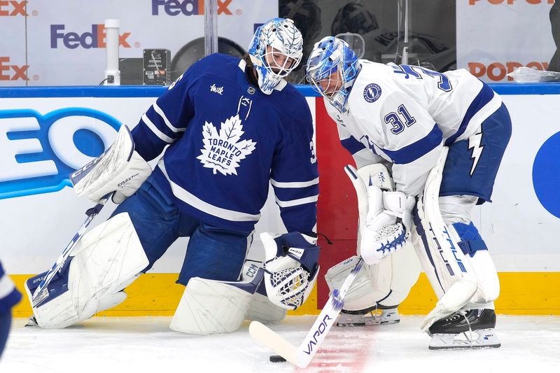 Oct 21, 2024; Toronto, Ontario, CAN; Toronto Maple Leafs goaltender Dennis Hildeby (35) and Tampa Bay Lightning goaltender Jonas Johansson (31) talk during warm-up at Scotiabank Arena. Mandatory Credit: John E. Sokolowski-Imagn Images