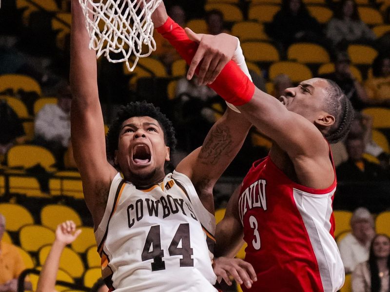 Feb 8, 2023; Laramie, Wyoming, USA; Wyoming Cowboys forward Caden Powell (44) is fouled by UNLV Runnin' Rebels guard Shane Nowell (3) during the second half at Arena-Auditorium. Mandatory Credit: Troy Babbitt-USA TODAY Sports