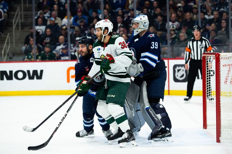 Feb 20, 2024; Winnipeg, Manitoba, CAN; Winnipeg Jets defenseman Dylan DeMelo (2), Minnesota Wild forward Connor Dewar (26) and Winnipeg Jets goalie Laurent Boissoit (39) look for the puck during first period at Canada Life Centre. Mandatory Credit: Terrence Lee-USA TODAY Sports