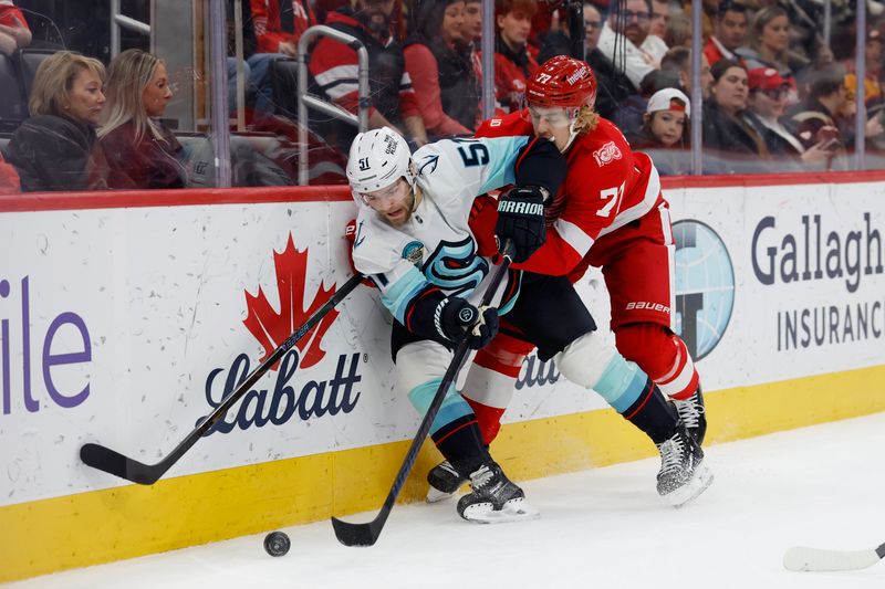 Nov 18, 2025; Detroit, Michigan, USA; Seattle Kraken center Shane Wright (51) battles Detroit Red Wings defenseman Simon Edvinsson (77) for the puck in the first period at Little Caesars Arena. Mandatory Credit: Rick Osentoski-Imagn Images