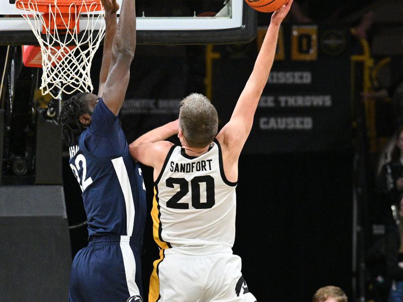 Feb 27, 2024; Iowa City, Iowa, USA; Penn State Nittany Lions forward Qudus Wahab (22) defends the shot of Iowa Hawkeyes forward Payton Sandfort (20) during the first half at Carver-Hawkeye Arena. Mandatory Credit: Jeffrey Becker-USA TODAY Sports