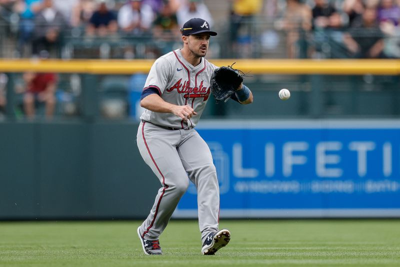 Aug 11, 2024; Denver, Colorado, USA; Atlanta Braves outfielder Adam Duvall (14) fields the ball in the third inning against the Colorado Rockies at Coors Field. Mandatory Credit: Isaiah J. Downing-USA TODAY Sports