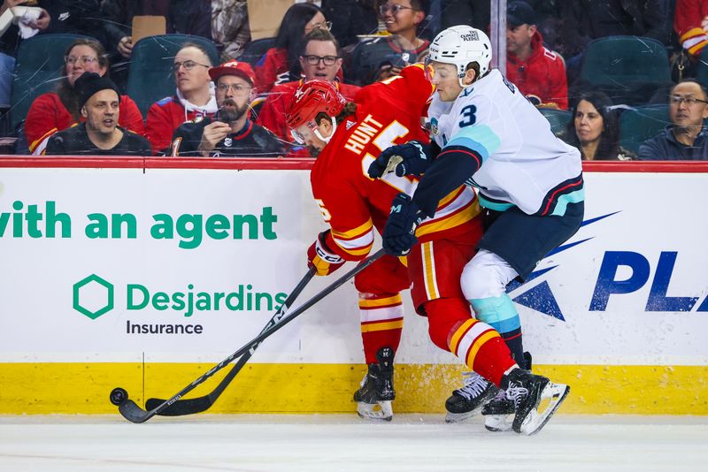 Mar 4, 2024; Calgary, Alberta, CAN; Calgary Flames left wing Dryden Hunt (15) and Seattle Kraken defenseman Will Borgen (3) battles for the puck during the first period at Scotiabank Saddledome. Mandatory Credit: Sergei Belski-USA TODAY Sports