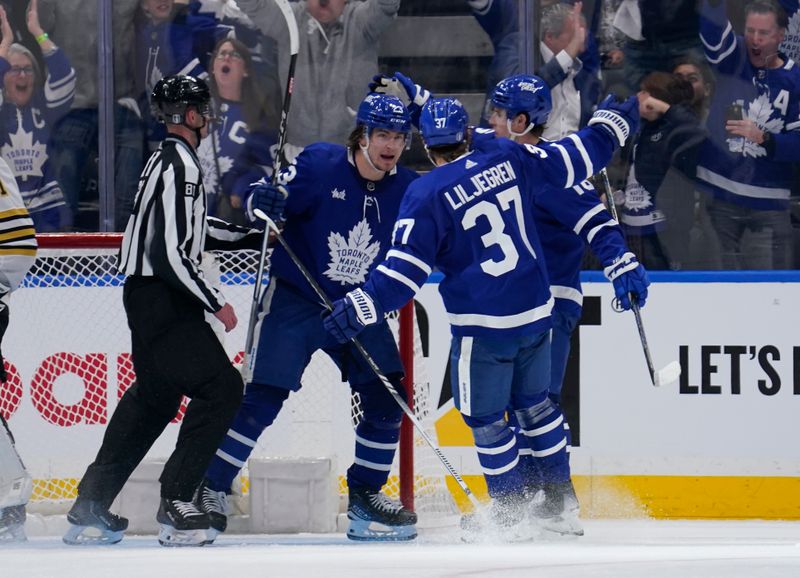 Apr 24, 2024; Toronto, Ontario, CAN; Toronto Maple Leafs defenseman Timothy Liljegren (37) congratulates Toronto Maple Leafs forward Matthew Knies (23) on his goal againt Boston Bruins goaltender Jeremy Swayman (1) during the second period of game three of the first round of the 2024 Stanley Cup Playoffs at Scotiabank Arena. Mandatory Credit: John E. Sokolowski-USA TODAY Sports