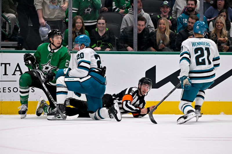 Nov 20, 2024; Dallas, Texas, USA; Dallas Stars left wing Jason Robertson (21) and San Jose Sharks left wing Fabian Zetterlund (20) and center Alexander Wennberg (21) and referee Michael Markovic (31) get up off the ice after they collide during the third period at the American Airlines Center. Mandatory Credit: Jerome Miron-Imagn Images