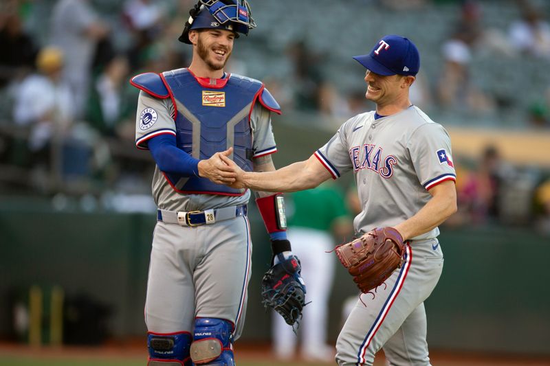 May 8, 2024; Oakland, California, USA; Texas Rangers catcher Jonah Heim (28) and pitcher David Robertson (37) share a laugh after striking out the side against the Oakland Athletics during the seventh inning at Oakland-Alameda County Coliseum. Mandatory Credit: D. Ross Cameron-USA TODAY Sports