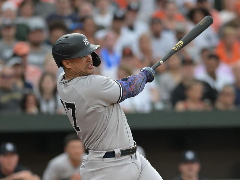 Jul 29, 2023; Baltimore, Maryland, USA; New York Yankees designated hitter Giancarlo Stanton (27) swings through  a solo home run in the first inning against the Baltimore Orioles  at Oriole Park at Camden Yards. Mandatory Credit: Tommy Gilligan-USA TODAY Sports