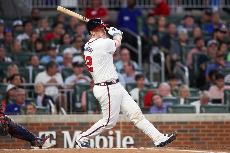 May 28, 2024; Atlanta, Georgia, USA; Atlanta Braves catcher Sean Murphy (12) hits a single against the Washington Nationals in the seventh inning at Truist Park. Mandatory Credit: Brett Davis-USA TODAY Sports