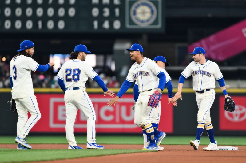Apr 16, 2023; Seattle, Washington, USA; Seattle Mariners third baseman Eugenio Suarez (28) and center fielder Julio Rodriguez (44) celebrate defeating the Colorado Rockies during the seventh inning at T-Mobile Park. Mandatory Credit: Steven Bisig-USA TODAY Sports