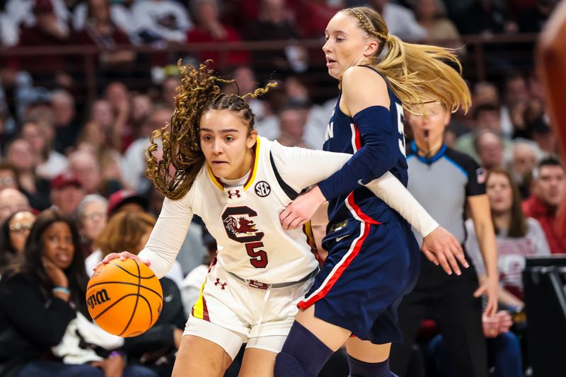 Feb 11, 2024; Columbia, South Carolina, USA; South Carolina Gamecocks guard Tessa Johnson (5) drives around UConn Huskies guard Paige Bueckers (5) in the first half at Colonial Life Arena. Mandatory Credit: Jeff Blake-USA TODAY Sports