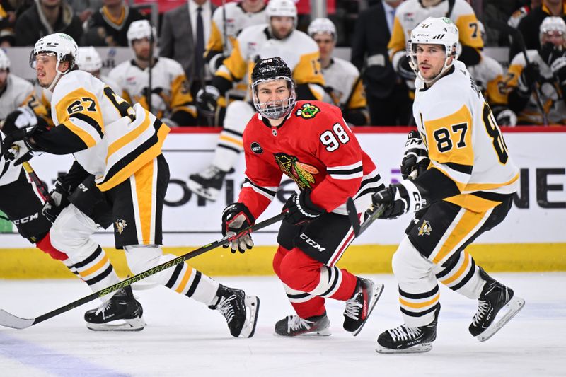 Feb 15, 2024; Chicago, Illinois, USA; Chicago Blackhawks forward Connor Bedard (98) and Pittsburgh Penguins forward Sidney Crosby (87) skate to the puck in the third period at United Center. Mandatory Credit: Jamie Sabau-USA TODAY Sports