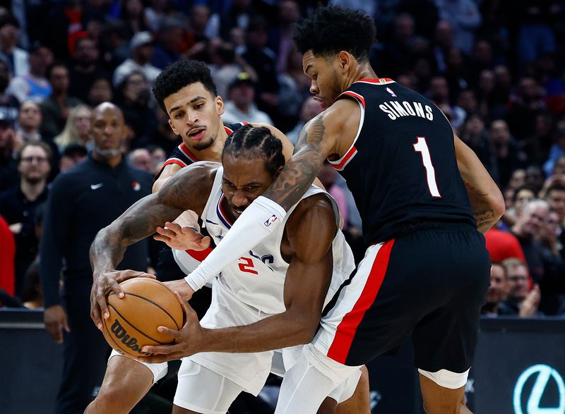 LOS ANGELES, CALIFORNIA - DECEMBER 11:  Kawhi Leonard #2 of the LA Clippers controls the ball against Anfernee Simons #1 and Toumani Camara #33 of the Portland Trail Blazers in the second half at Crypto.com Arena on December 11, 2023 in Los Angeles, California.  NOTE TO USER: User expressly acknowledges and agrees that, by downloading and/or using this photograph, user is consenting to the terms and conditions of the Getty Images License Agreement. (Photo by Ronald Martinez/Getty Images)