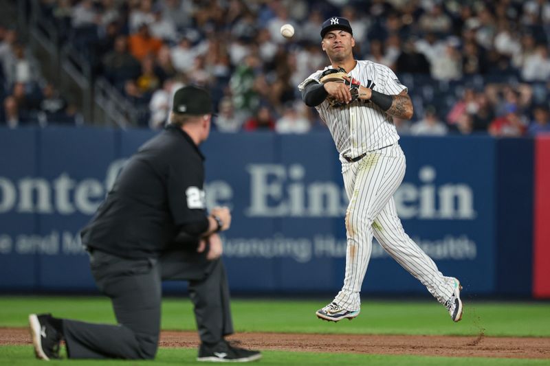 Sep 10, 2024; Bronx, New York, USA; New York Yankees second baseman Gleyber Torres (25) throws the ball to first base for an out during the fourth inning against the Kansas City Royals at Yankee Stadium. Mandatory Credit: Vincent Carchietta-Imagn Images