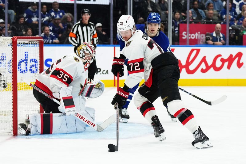 Nov 12, 2024; Toronto, Ontario, CAN; Ottawa Senators defenseman Thomas Chabot (72) controls the puck as Toronto Maple Leafs left wing Matthew Knies (23) looks for a rebound during the third period at Scotiabank Arena. Mandatory Credit: Nick Turchiaro-Imagn Images