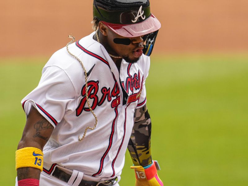 May 21, 2023; Cumberland, Georgia, USA; Atlanta Braves right fielder Ronald Acuna Jr. (13) loses one of his chains as he scores a run against the Seattle Mariners during the first inning at Truist Park. Mandatory Credit: Dale Zanine-USA TODAY Sports