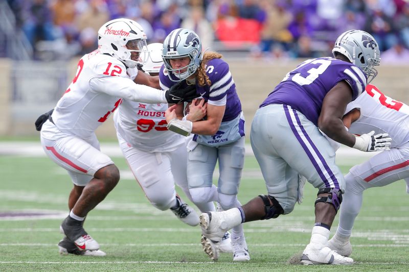 Oct 28, 2023; Manhattan, Kansas, USA; Kansas State Wildcats quarterback Avery Johnson (5) is tackled by Houston Cougars defensive lineman David Ugwoegbu (12) during the fourth quarter at Bill Snyder Family Football Stadium. Mandatory Credit: Scott Sewell-USA TODAY Sports