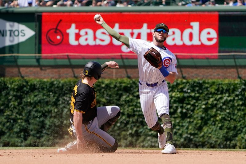 May 19, 2024; Chicago, Illinois, USA; Chicago Cubs shortstop Miles Mastrobuoni (20) forces out Pittsburgh Pirates outfielder Jack Suwinski (65) at second base then throws to first base to complete a double play during the fourth inning at Wrigley Field. Mandatory Credit: David Banks-USA TODAY Sports