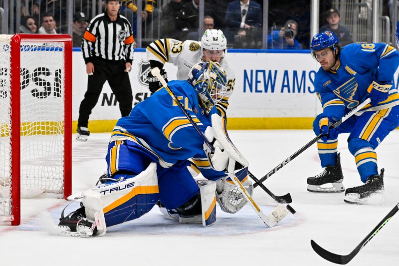 Jan 13, 2024; St. Louis, Missouri, USA;  St. Louis Blues goaltender Jordan Binnington (50) defends the net against Boston Bruins left wing Brad Marchand (63) during the third period at Enterprise Center. Mandatory Credit: Jeff Curry-USA TODAY Sports