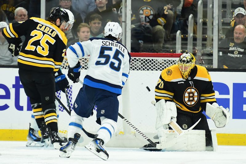 Jan 30, 2025; Boston, Massachusetts, USA;  Boston Bruins goaltender Joonas Korpisalo (70) makes a save in front of Winnipeg Jets center Mark Scheifele (55) and defenseman Brandon Carlo (25) during the first period at TD Garden. Mandatory Credit: Bob DeChiara-Imagn Images