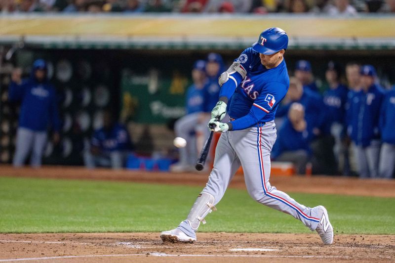 Sep 24, 2024; Oakland, California, USA; Texas Rangers first baseman Nathaniel Lowe (30) hits a solo home run against Oakland Athletics during the fourth inning at Oakland-Alameda County Coliseum. Mandatory Credit: Neville E. Guard-Imagn Images