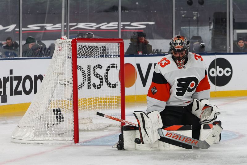 Feb 17, 2024; East Rutherford, New Jersey, USA; Philadelphia Flyers goaltender Samuel Ersson (33) makes a save against the New Jersey Devils during the second period in a Stadium Series ice hockey game at MetLife Stadium. Mandatory Credit: Ed Mulholland-USA TODAY Sports