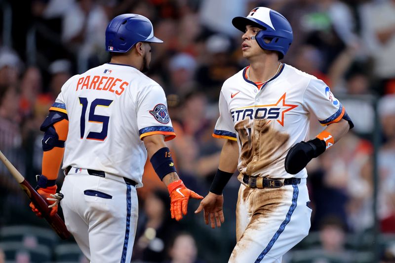 Apr 13, 2025; Houston, Texas, USA; Houston Astros second baseman Mauricio Dubón (14) is congraulated by Houston Astros third baseman Isaac Paredes (15) after scoring a run score against the Los Angeles Angels during the seventh inning at Daikin Park. Mandatory Credit: Erik Williams-Imagn Images