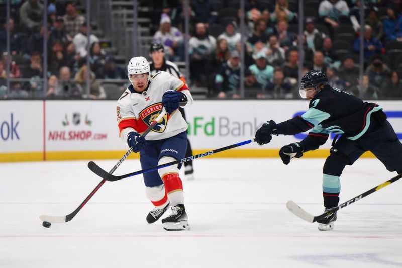 Dec 12, 2023; Seattle, Washington, USA; Florida Panthers center Evan Rodrigues (17) passes the puck past Seattle Kraken right wing Jordan Eberle (7) during the third period at Climate Pledge Arena. Mandatory Credit: Steven Bisig-USA TODAY Sports