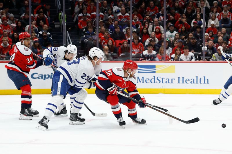 Nov 28, 2025; Washington, District of Columbia, USA; Washington Capitals defenseman Rasmus Sandin (38) and Toronto Maple Leafs left wing Matthew Knies (23) battle for the puck during the second period at Capital One Arena. Mandatory Credit: Geoff Burke-Imagn Images