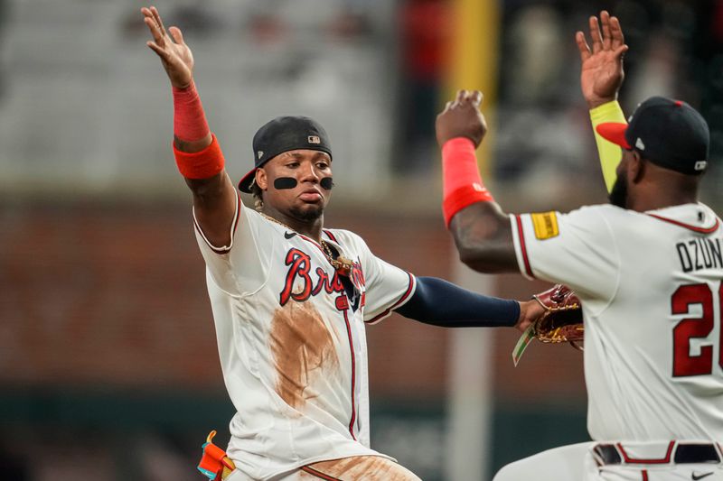 Aug 15, 2023; Cumberland, Georgia, USA; Atlanta Braves right fielder Ronald Acuna Jr. (13) reacts with designated hitter Marcell Ozuna (20) after the Braves defeated the New York Yankees at Truist Park. Mandatory Credit: Dale Zanine-USA TODAY Sports