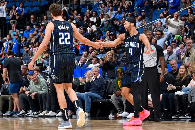 ORLANDO, FL - MARCH 19: Jalen Suggs #4 of the Orlando Magic high fives Franz Wagner #22 during the game against the Charlotte Hornets on March 19, 2024 at the Kia Center in Orlando, Florida. NOTE TO USER: User expressly acknowledges and agrees that, by downloading and or using this photograph, User is consenting to the terms and conditions of the Getty Images License Agreement. Mandatory Copyright Notice: Copyright 2024 NBAE (Photo by Gary Bassing/NBAE via Getty Images)