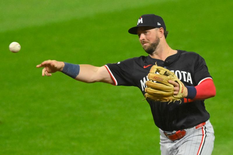 Sep 17, 2024; Cleveland, Ohio, USA; Minnesota Twins second baseman Kyle Farmer (12) throws to first base in the seventh inning against the Cleveland Guardians at Progressive Field. Mandatory Credit: David Richard-Imagn Images