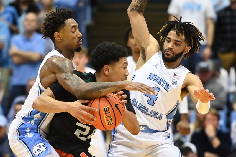 Feb 13, 2023; Chapel Hill, North Carolina, USA; Miami (Fl) Hurricanes guard Nijel Pack (24) with the ball as North Carolina Tar Heels forward Leaky Black (1) and guard R.J. Davis (4) pressure in the second half at Dean E. Smith Center. Mandatory Credit: Bob Donnan-USA TODAY Sports