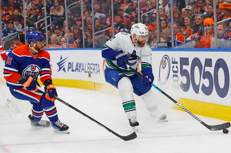 Apr 13, 2024; Edmonton, Alberta, CAN; Vancouver Canucks defensemen Ian Cole (82) and Edmonton Oilers forward Evander Kane (91) Battle along the boards for a loose puck  during the first period at Rogers Place. Mandatory Credit: Perry Nelson-USA TODAY Sports