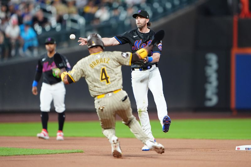 Jun 14, 2024; New York City, New York, USA;  New York Mets second baseman Jeff McNeil (1) turns a double play with San Diego Padres first baseman Luis Arraez (4) sliding into second base during the first inning at Citi Field. Mandatory Credit: Gregory Fisher-USA TODAY Sports