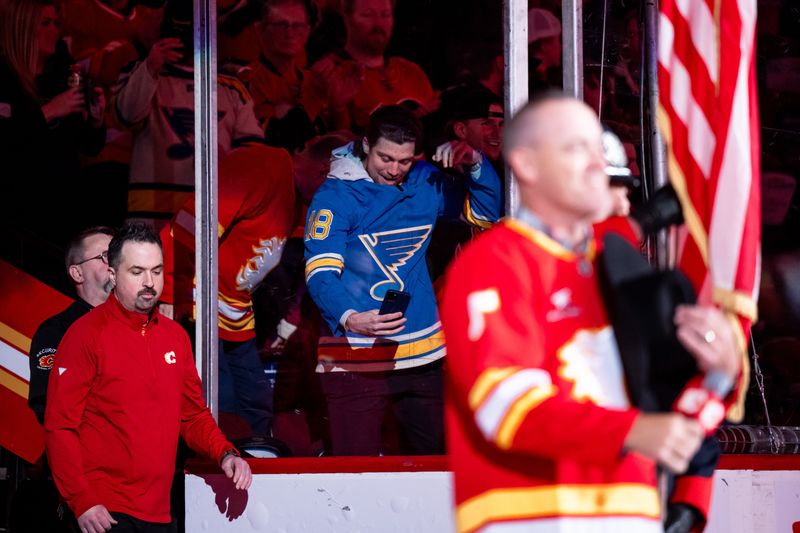 Dec 5, 2024; Calgary, Alberta, CAN; A St. Louis Blues fan smiles after singing the national anthems ahead of a game between the Calgary Flames and St. Louis Blues at Scotiabank Saddledome. Mandatory Credit: Brett Holmes-Imagn Images