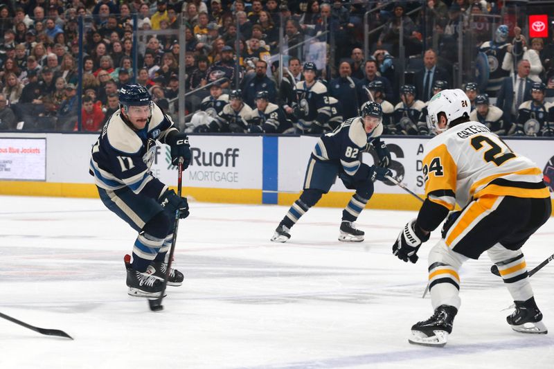 Nov 15, 2024; Columbus, Ohio, USA; Columbus Blue Jackets right wing Justin Danforth (17) wrists a shot on goal   as Pittsburgh Penguins defenseman Matt Grzelcyk (24) defends during the first period at Nationwide Arena. Mandatory Credit: Russell LaBounty-Imagn Images