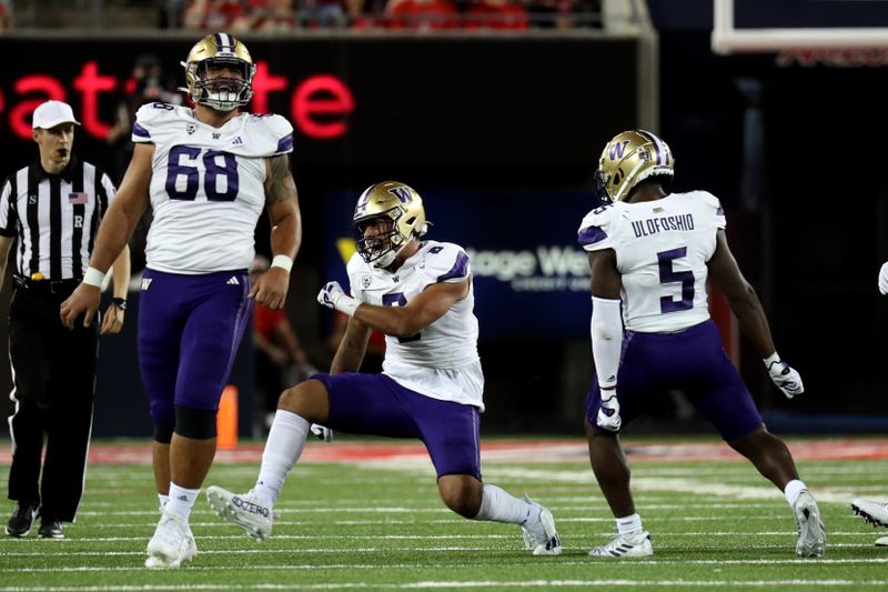 Sep 30, 2023; Tucson, Arizona, USA; Washington Huskies defensive end Bralen Trice (8), defensive lineman Ulumoo Ale (68), and linebacker Edefuan Ulofoshio (5) celebrate a tackle for a loss in the second half at Arizona Stadium. Mandatory Credit: Zachary BonDurant-USA TODAY Sports