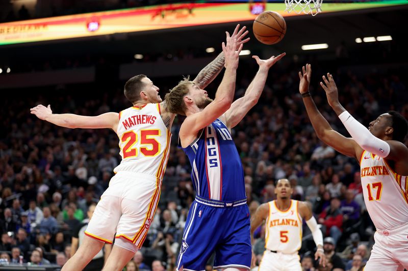 SACRAMENTO, CALIFORNIA - JANUARY 22: Domantas Sabonis #10 of the Sacramento Kings goes for a rebound against Garrison Mathews #25 and Onyeka Okongwu #17 of the Atlanta Hawks in the first half at Golden 1 Center on January 22, 2024 in Sacramento, California. NOTE TO USER: User expressly acknowledges and agrees that, by downloading and or using this photograph, User is consenting to the terms and conditions of the Getty Images License Agreement.  (Photo by Ezra Shaw/Getty Images)