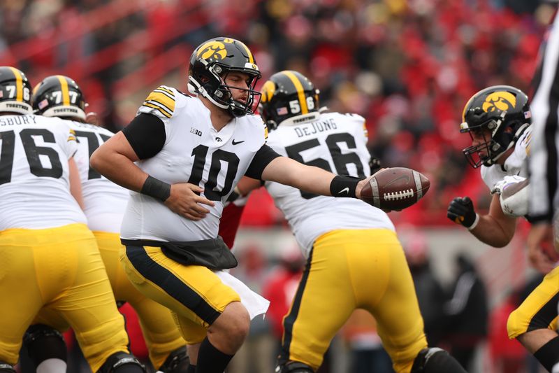 Nov 24, 2023; Lincoln, Nebraska, USA; Iowa Hawkeyes quarterback Deacon Hill (10) hands off the football to Iowa Hawkeyes running back Kaleb Johnson (2) at Memorial Stadium. Mandatory Credit: Reese Strickland-USA TODAY Sports