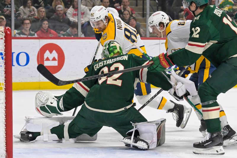 Jan 25, 2024; Saint Paul, Minnesota, USA; Minnesota Wild goalie Filip Gustavsson (32) makes a save on Nashville Predators forward Tommy Novak (82) during the first period at Xcel Energy Center. Mandatory Credit: Nick Wosika-USA TODAY Sports