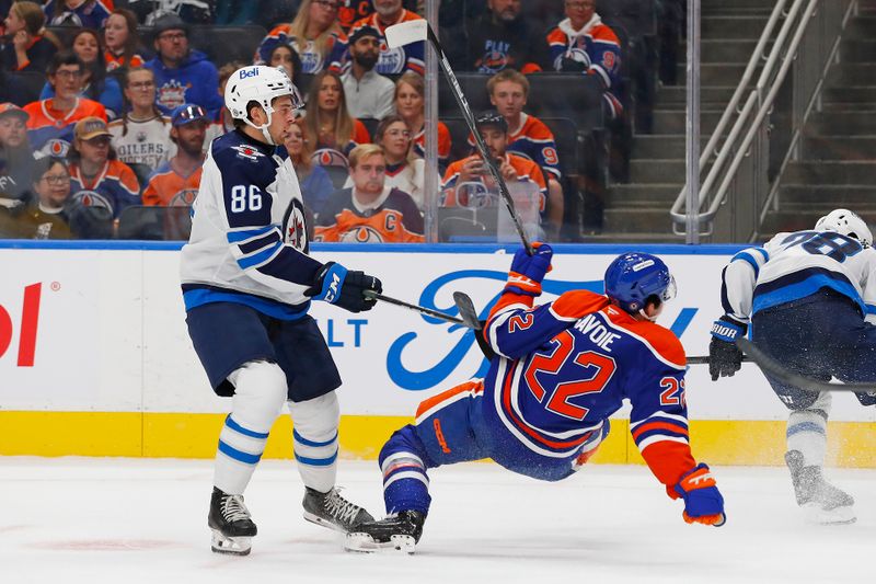 Sep 22, 2024; Edmonton, Alberta, CAN; Winnipeg Jets defensemen Dawson Bartteaux (86) trips up Edmonton Oilers Forward Matt Savoie (22) during the first period at Rogers Place. Mandatory Credit: Perry Nelson-Imagn Images