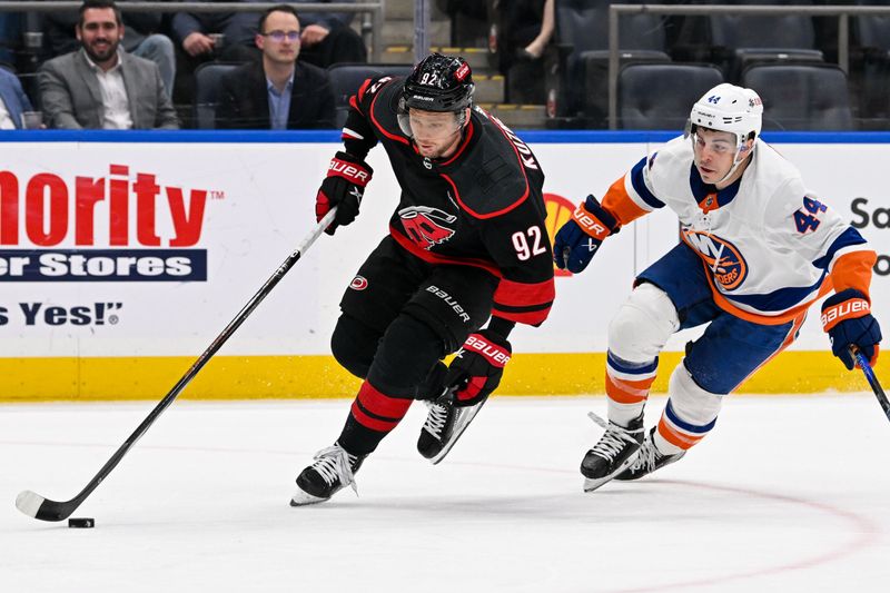 Mar 19, 2024; Elmont, New York, USA; Carolina Hurricanes center Evgeny Kuznetsov (92) skates with the puck chased by New York Islanders center Jean-Gabriel Pageau (44) during the second period at UBS Arena. Mandatory Credit: Dennis Schneidler-USA TODAY Sports