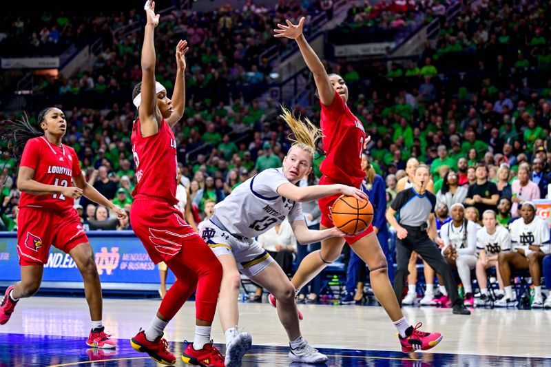 Mar 3, 2024; South Bend, Indiana, USA; Notre Dame Fighting Irish guard Anna Dewolfe (13) passes the ball as Louisville Cardinals guard Nina Rickards (15) and forward Nyla Harris (2) defend in the second half at the Purcell Pavilion. Mandatory Credit: Matt Cashore-USA TODAY Sports