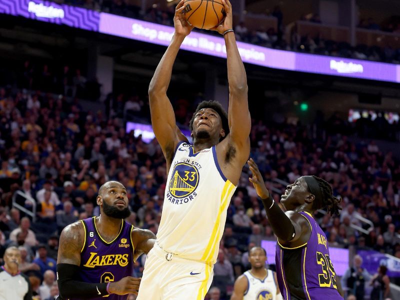 SAN FRANCISCO, CALIFORNIA - OCTOBER 18: James Wiseman #33 of the Golden State Warriors goes up for a dunk on LeBron James #6 and Wenyen Gabriel #35 of the Los Angeles Lakers at Chase Center on October 18, 2022 in San Francisco, California. NOTE TO USER: User expressly acknowledges and agrees that, by downloading and or using this photograph, User is consenting to the terms and conditions of the Getty Images License Agreement. (Photo by Ezra Shaw/Getty Images)