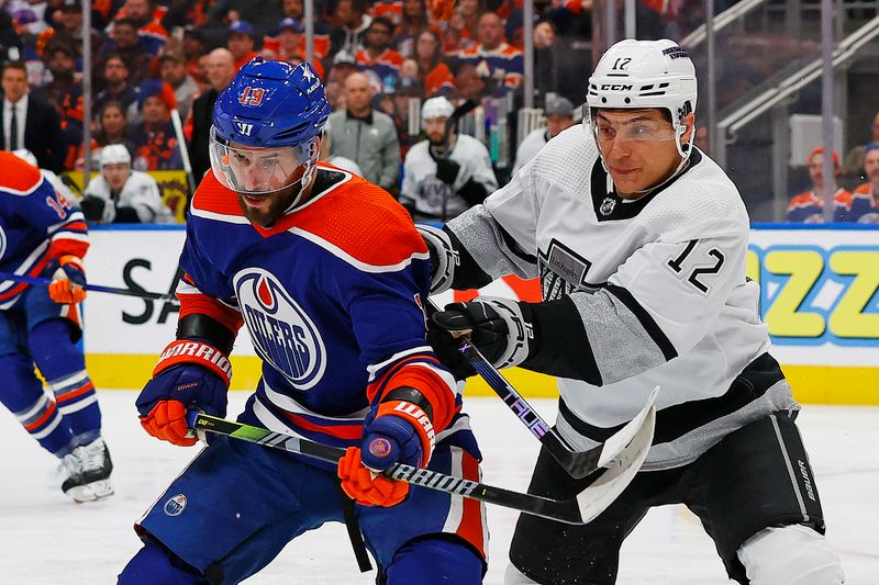 Apr 22, 2024; Edmonton, Alberta, CAN; Edmonton Oilers forward Adam Henrique (19) and Los Angeles Kings forward Trevor Moore (12) battle for a loose puck during the first period in game one of the first round of the 2024 Stanley Cup Playoffs at Rogers Place. Mandatory Credit: Perry Nelson-USA TODAY Sports