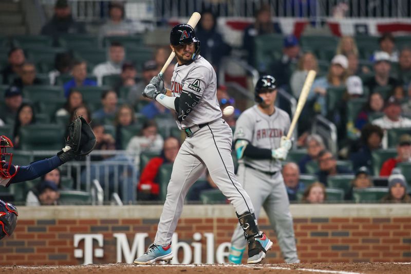 Apr 6, 2024; Atlanta, Georgia, USA; Arizona Diamondbacks third baseman Eugenio Suarez (28) is hit by a pitch against the Atlanta Braves in the ninth inning at Truist Park. Mandatory Credit: Brett Davis-USA TODAY Sports