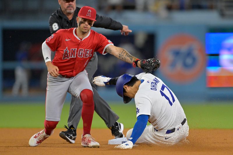 Jun 21, 2024; Los Angeles, California, USA;  Los Angeles Dodgers designated hitter Shohei Ohtani (17) is tagged out by Los Angeles Angels shortstop Zach Neto (9) on an attempted stolen base in the eighth inning at Dodger Stadium. Mandatory Credit: Jayne Kamin-Oncea-USA TODAY Sports