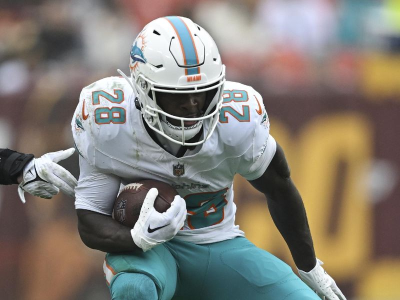 Miami Dolphins running back De'Von Achane (28) runs the ball during the second half of an NFL football game against the Washington Commanders, Sunday, Dec. 2, 2023, in Landover, Md. (AP Photo/Terrance Williams)