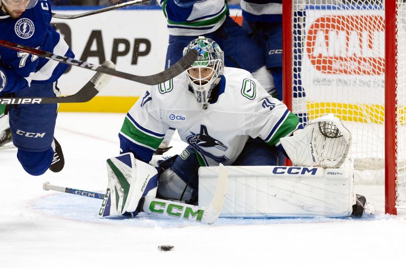 Oct 15, 2024; Tampa, Florida, USA; Vancouver Canucks goaltender Arturs Silovs (31) makes a save against the Tampa Bay Lightning during the first period at Amalie Arena. Mandatory Credit: Kim Klement Neitzel-Imagn Images